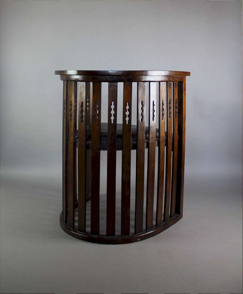 Arts and Crafts mahogany barrel chair with pierced cutouts. c1910