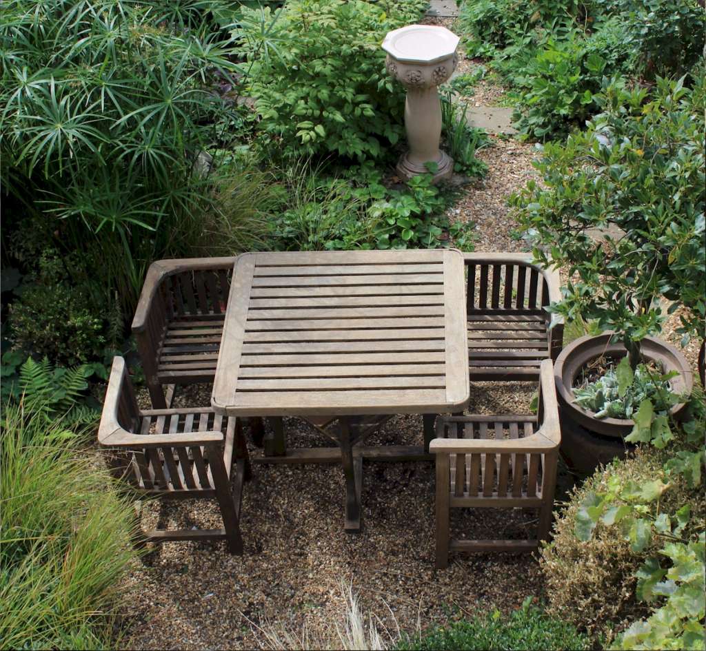  Heals teak garden table and four chairs. c1930